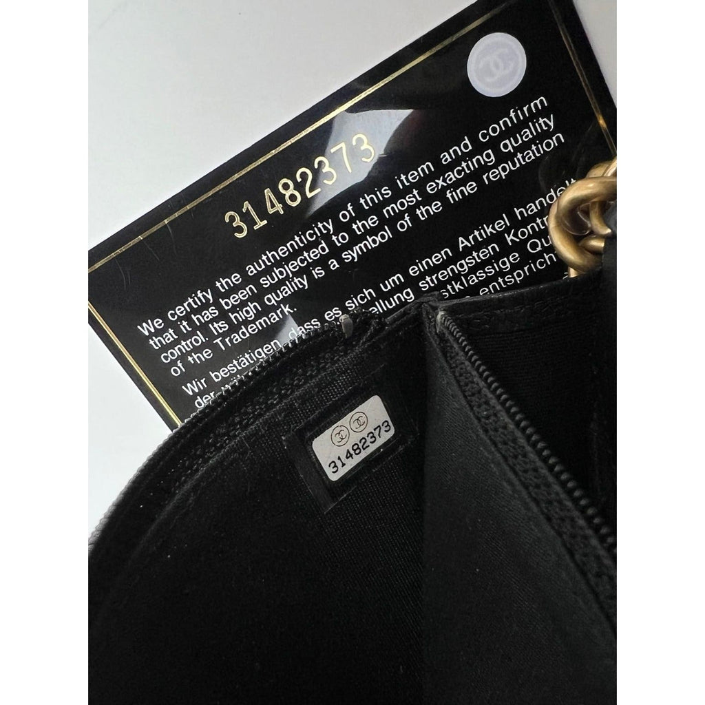 Ví cầm tay Chanel Caviar Quilted Mini Boy có dây xích màu đen