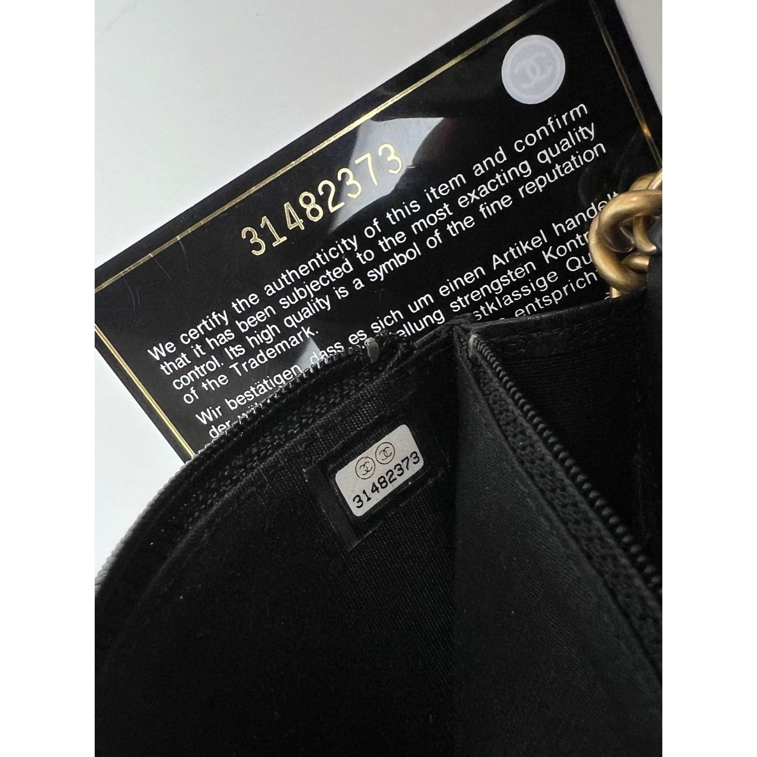 Ví cầm tay Chanel Caviar Quilted Mini Boy có dây xích màu đen